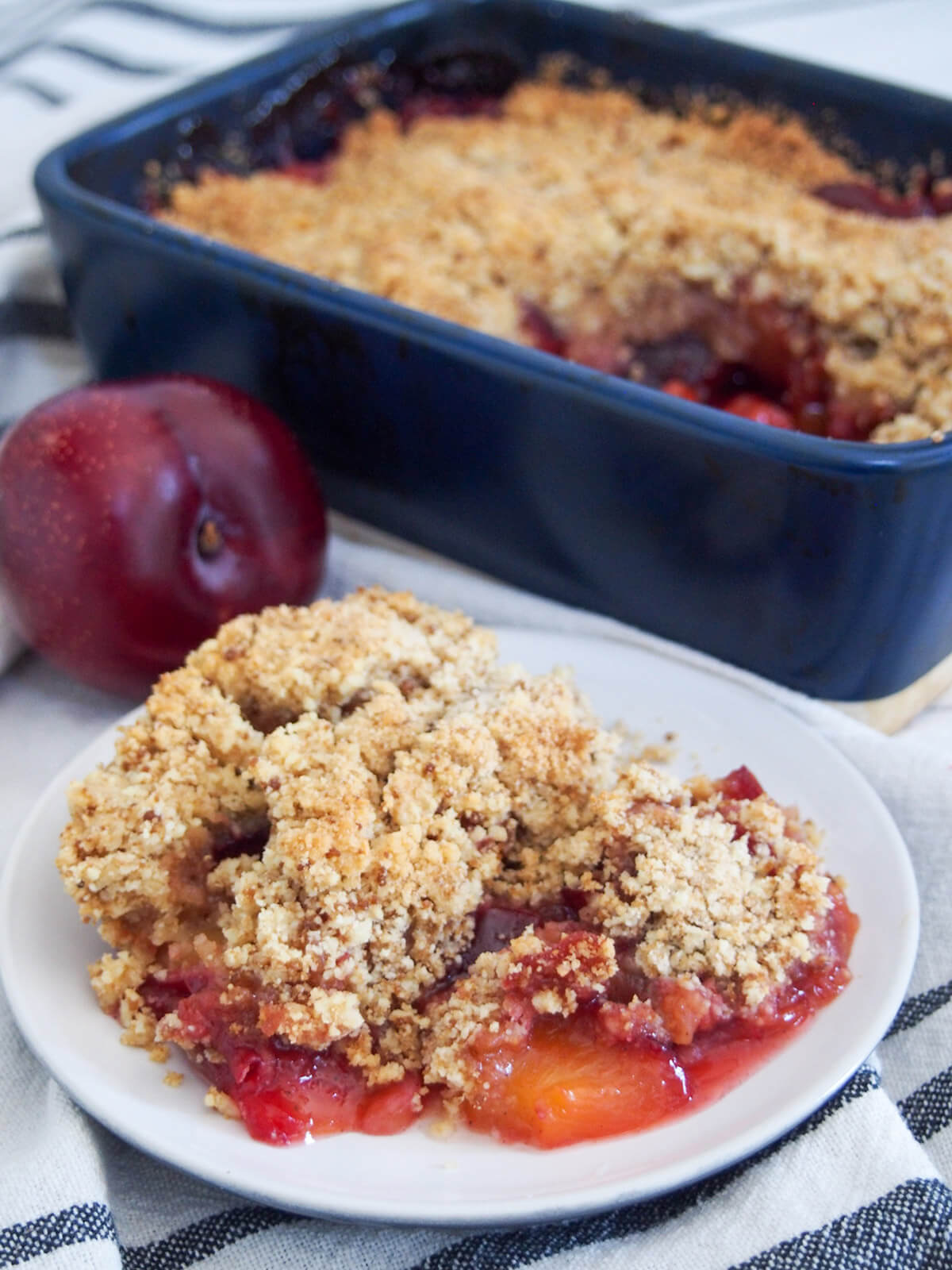 plate with some plum crumble with rest in dish behind