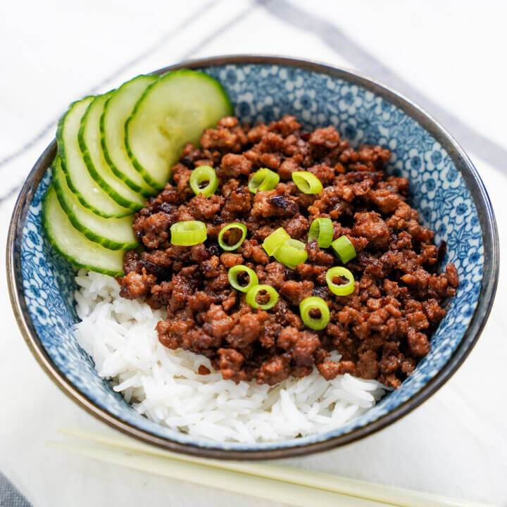 bowl of Taiwanese minced pork rice with cucumber at back of bowl.